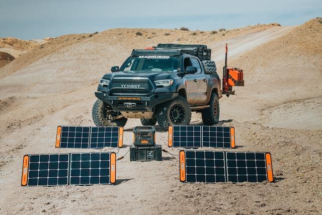 truck on a sandy hill with portable solar panels