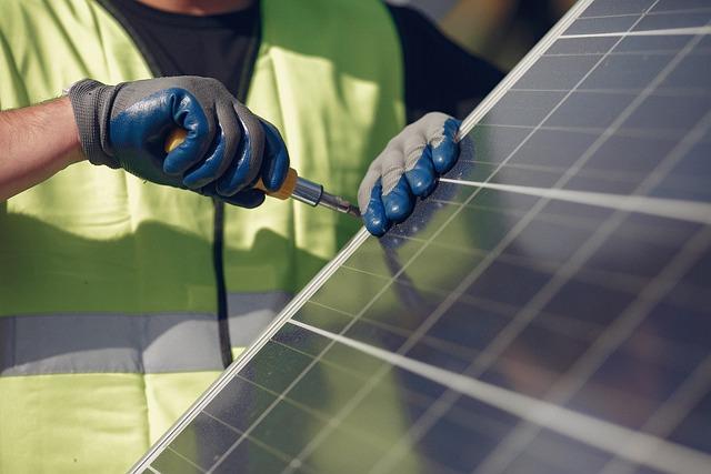 Man using screwdriver to fix solar panel