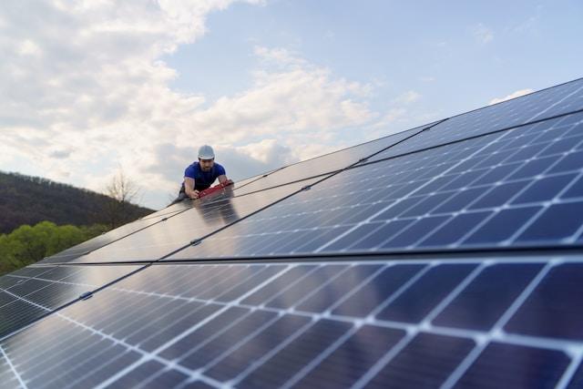Man using bubbler to see angle of installed solar panels on roof